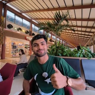 Waleed giving a thumbs up in a café